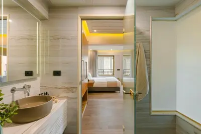 a bathroom with a sink and a bedroom at Querini Luxury Suites in Chania Town