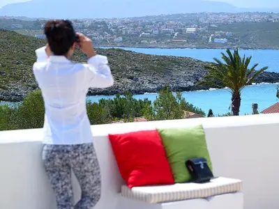 a woman standing on a bench talking on a cell phone at Villa Mare in Tersanas