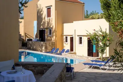 a pool with chairs and a table and a building at Iliopetra in Douliana