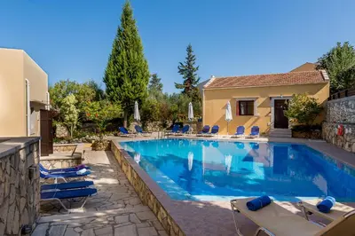 a swimming pool with chairs and a house at Iliopetra in Douliana