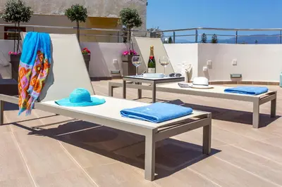 two beds with hats on them on a rooftop at Angels Suites in Plataniás