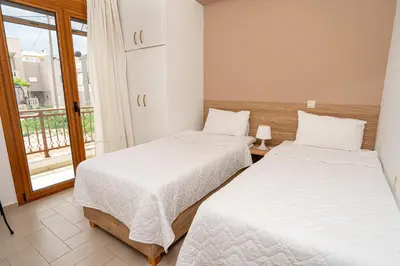 two beds in a room with a window at Contemporary 2 bedroom apt 5 min walk from Kissamos center in Kissamos