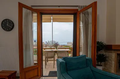 a living room with a blue couch and a clock at Contemporary 2 bedroom apt 5 min walk from Kissamos center in Kissamos