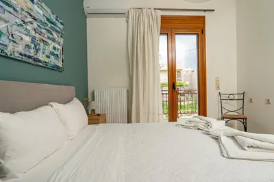a bedroom with a large white bed with a window at Contemporary 2 bedroom apt 5 min walk from Kissamos center in Kissamos