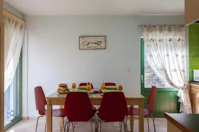 a dining room with a table and red chairs at Augusta Country House in Derés