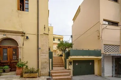 an alley between two buildings with a green door at Lithinon House in Chania Town