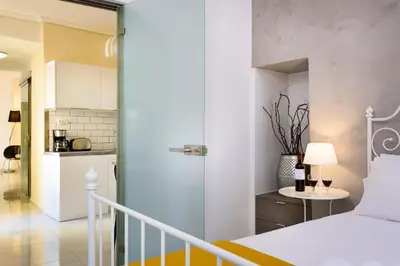 a bedroom with a bed and a kitchen at Lithinon House in Chania Town