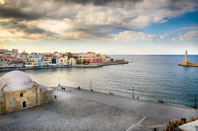 a view of a city and the water with a lighthouse at Lithinon House in Chania Town