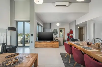 a living room with a table and a television at Elysium Seaview Oasis in Kato Galatas