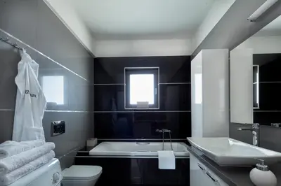 a bathroom with a tub and a toilet and a sink at Elysium Seaview Oasis in Kato Galatas