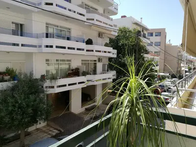 a building with a palm tree in front of it at City Square Apartment in Chania Town