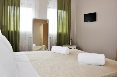 a bedroom with a large white bed with a mirror at Villa Lakki Heated round pool Jacuzzi in Lákkoi