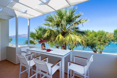 a dining room with a table and chairs and the ocean at Big Blue Villa in Kisamos, 10 meters from Sea in Kissamos