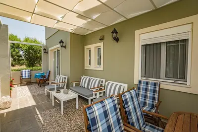a porch with chairs and a couch and a table at Big Blue Villa in Kisamos, 10 meters from Sea in Kissamos
