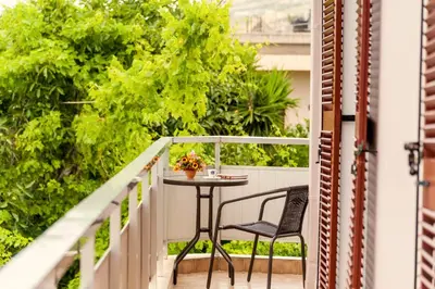 a table and a chair on a balcony at Falassarna House in Plátanos