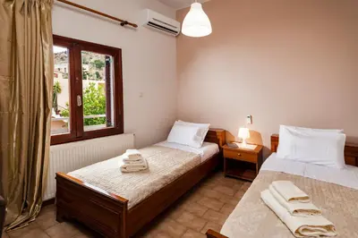 a bedroom with two beds and a window at Falassarna House in Plátanos