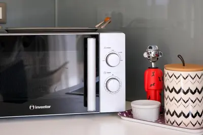a microwave sitting on a counter next to a cup at Glaros Casa Verde - Cozy flat with Garden near Beach in Kato Daratso