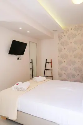 a bedroom with a bed with a tv on the wall at Glaros Casa Verde - Cozy flat with Garden near Beach in Kato Daratso