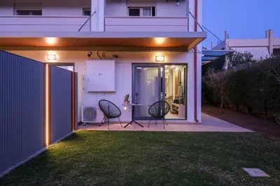 a patio with two chairs and a table with lights at Glaros Casa Verde - Cozy flat with Garden near Beach in Kato Daratso