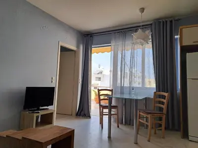 a living room with a dining room table and a television at Nais Apartments & Studios in Chania Town