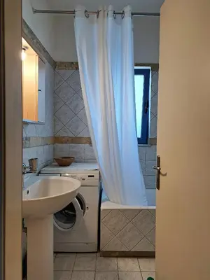 a bathroom with a sink and a shower curtain at Nais Apartments & Studios in Chania Town