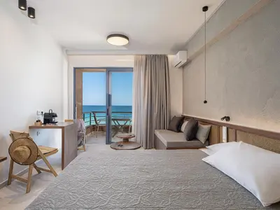 a hotel room with a bed and a view of the ocean at Nais Apartments & Studios in Chania Town