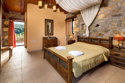 a bedroom with a bed and a stone wall at Villa Kimothoe with Private Pool, only 20 min to Elafonissi Beach in AmigdhalokeFálion