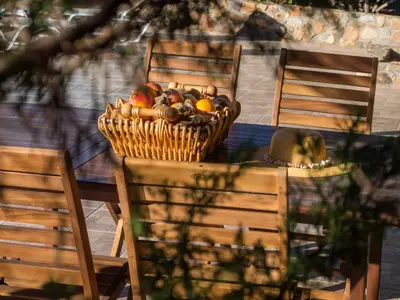 a basket of fruit sitting on a table with chairs at Villa Kimothoe with Private Pool, only 20 min to Elafonissi Beach in AmigdhalokeFálion