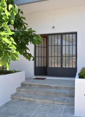 a front door of a white building with stairs at Evaris Apartments in Chania Town