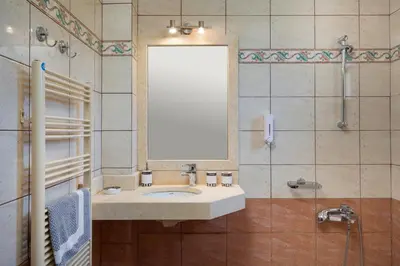 a bathroom with a sink and a mirror and a shower at Adam Villas in Falasarna