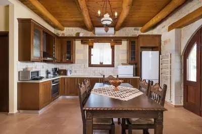 a kitchen with a table and chairs and a refrigerator at Adam Villas in Falasarna