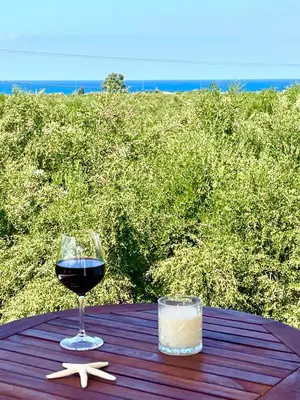a glass of wine sitting on a table with a drink at Sunny Villa in Kissamos