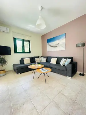 a living room with a couch and a table at Sunny Villa in Kissamos