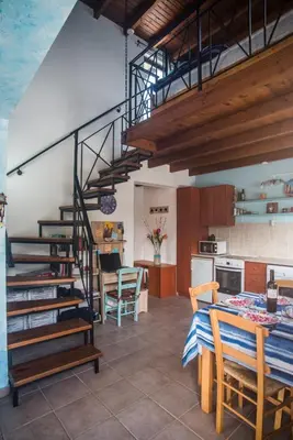 a kitchen and dining room with a spiral staircase at Villa Afou in Afráta