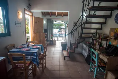 a dining room with a table and a staircase at Villa Afou in Afráta