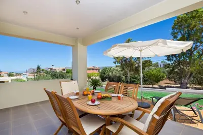 a dining room with a table and chairs and an umbrella at Villa Detoro in Kambánion