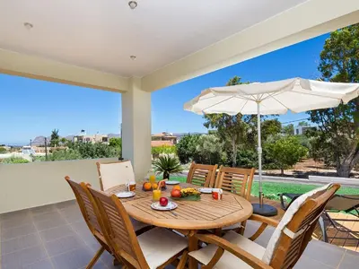 a dining room with a table and an umbrella at Villa Detoro in Kambánion