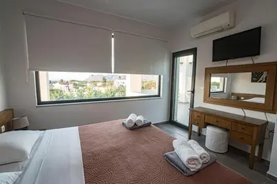 a bedroom with a bed with a desk and a mirror at Villa Detoro in Kambánion