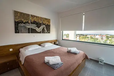 a bedroom with a large bed and a large window at Villa Detoro in Kambánion