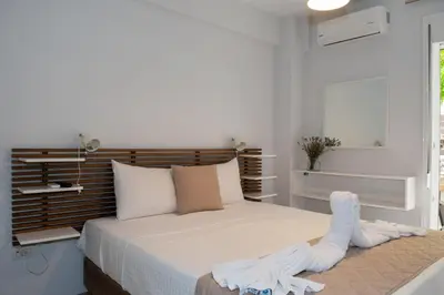 a white bedroom with a bed with towels on it at Urban 35 in Chania Town