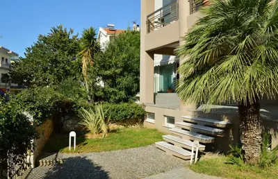 a building with a bench next to a palm tree at Urban 35 in Chania Town
