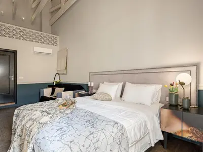 a bedroom with a large bed with a white blanket at Elia Palatino Hotel in Chania Town
