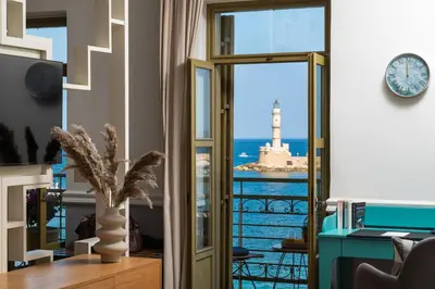 a room with a view of the ocean and a lighthouse at Elia Palatino Hotel in Chania Town