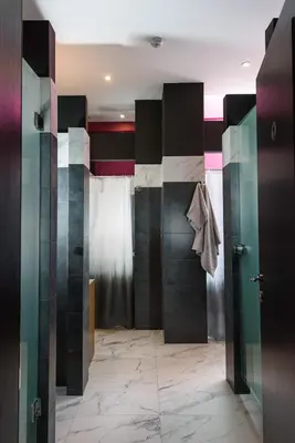 a bathroom with black and white walls and a walk in shower at Cocoon City Hostel in Chania Town