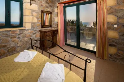 a bedroom with a bed and a window with a view at Sea-Sunset Views Villa Lefkothea with Private Pool near Elafonissi in AmigdhalokeFálion