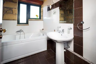 a bathroom with a tub and a sink and a bath tub at Sea-Sunset Views Villa Lefkothea with Private Pool near Elafonissi in AmigdhalokeFálion