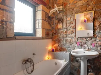 a bathroom with a bath tub and a sink and a mirror at Sea-Sunset Views Villa Lefkothea with Private Pool near Elafonissi in AmigdhalokeFálion