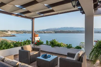 a patio with a view of the water at Alianthos Villa in Tersanas