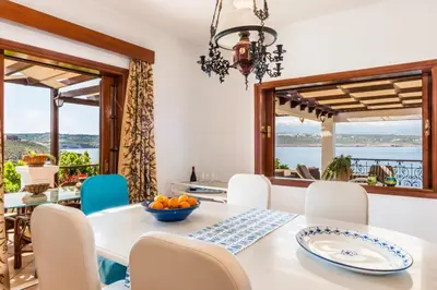 a dining room with a table and chairs with a view at Alianthos Villa in Tersanas