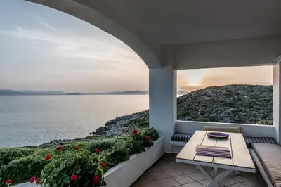a balcony with a table and a view of the water at Alianthos Villa in Tersanas